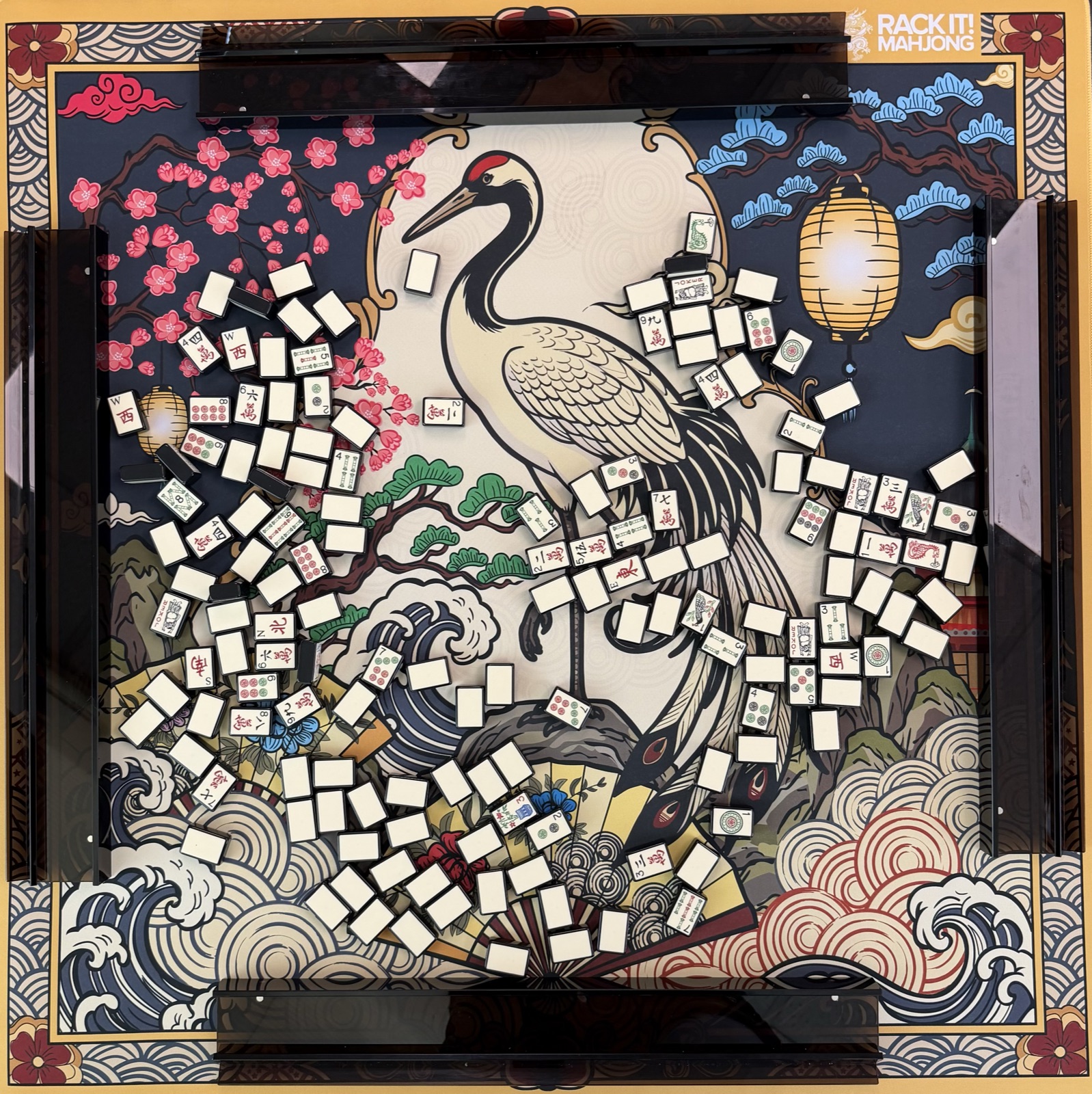 Shuffled tiles face down on a crane-print Mahjong mat
