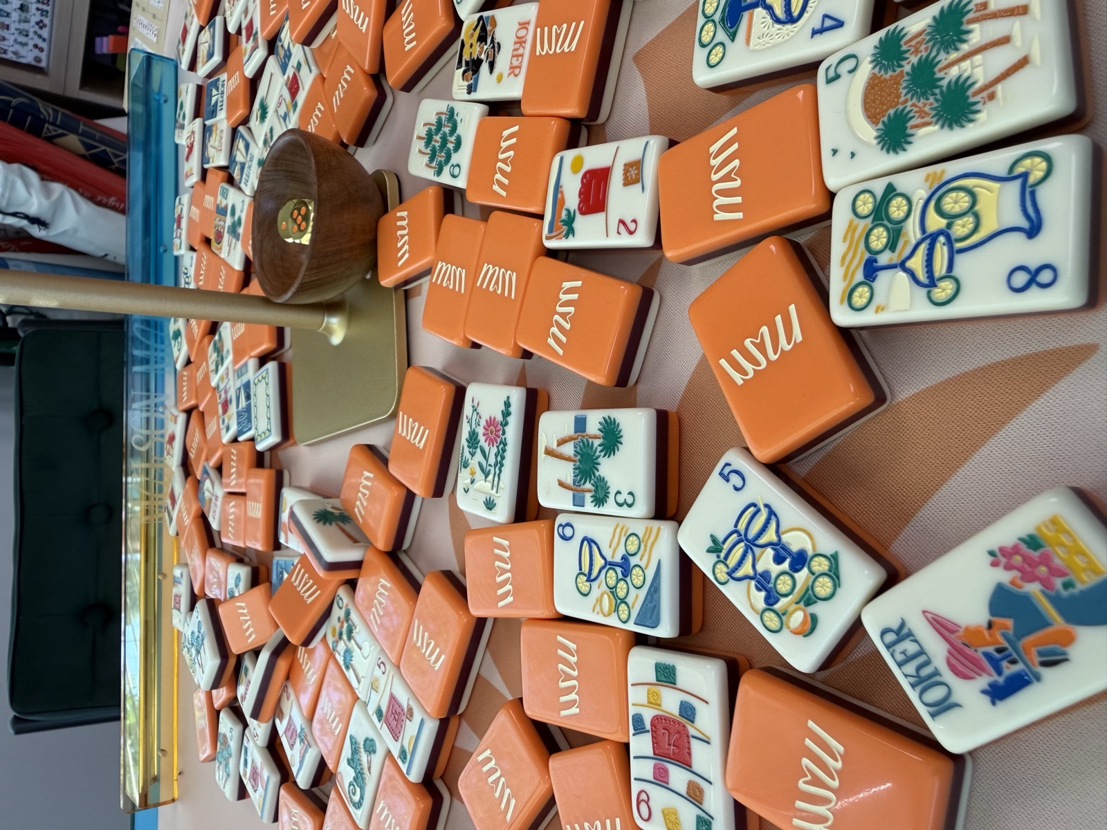 Close-up of an orange American Mahjong tile set spread across the table